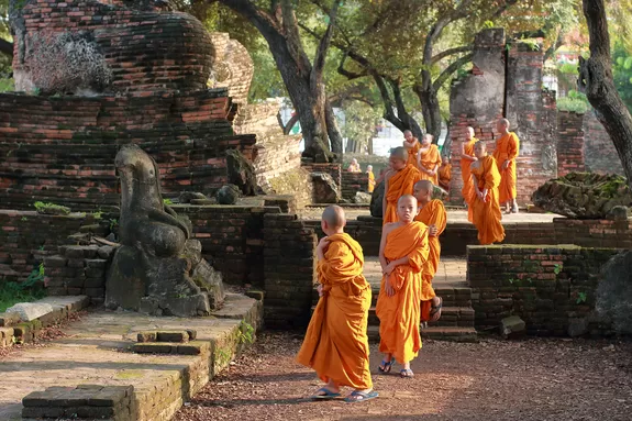 Junge Mönche zwischen alten Tempeln in Thailand