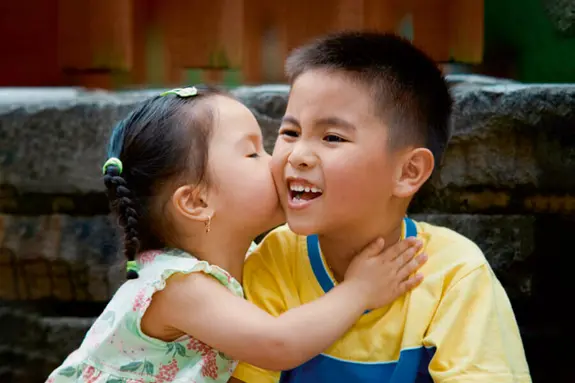 Fröhliche chinesische Kinder vor alten Mauern