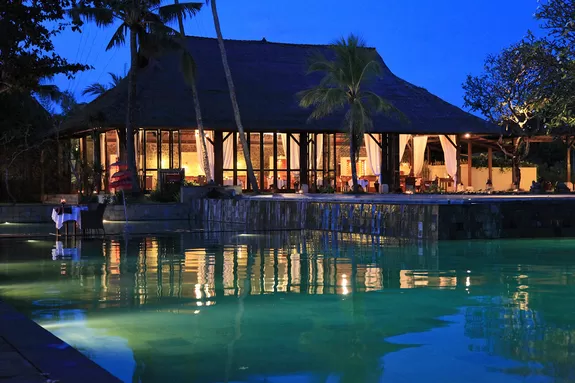 Abendstimmung über Restaurant und Pool des Jimbaran Puri Hotels