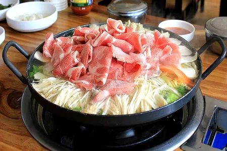Japanische Küche: Sukiyaki mit Fleisch und Gemüse in Brühe