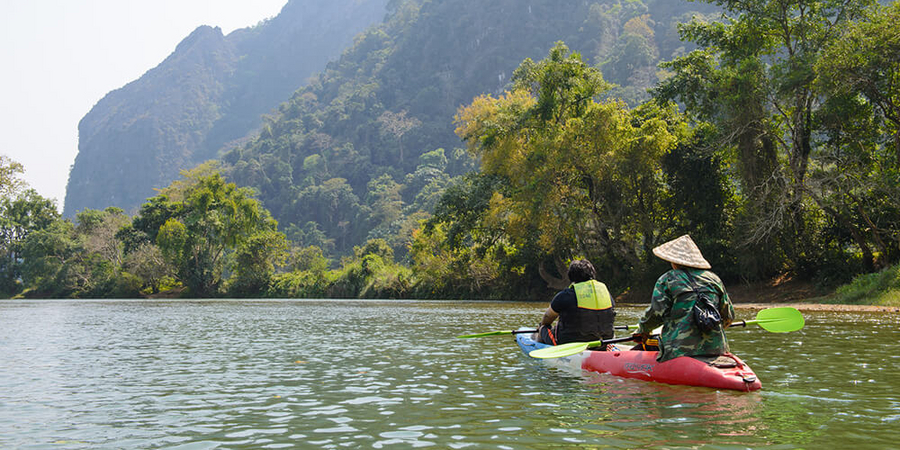 Die märchenhafte Landschaft mit Fluss und Karstbergen von Vang Vieng per Kajak entdecken